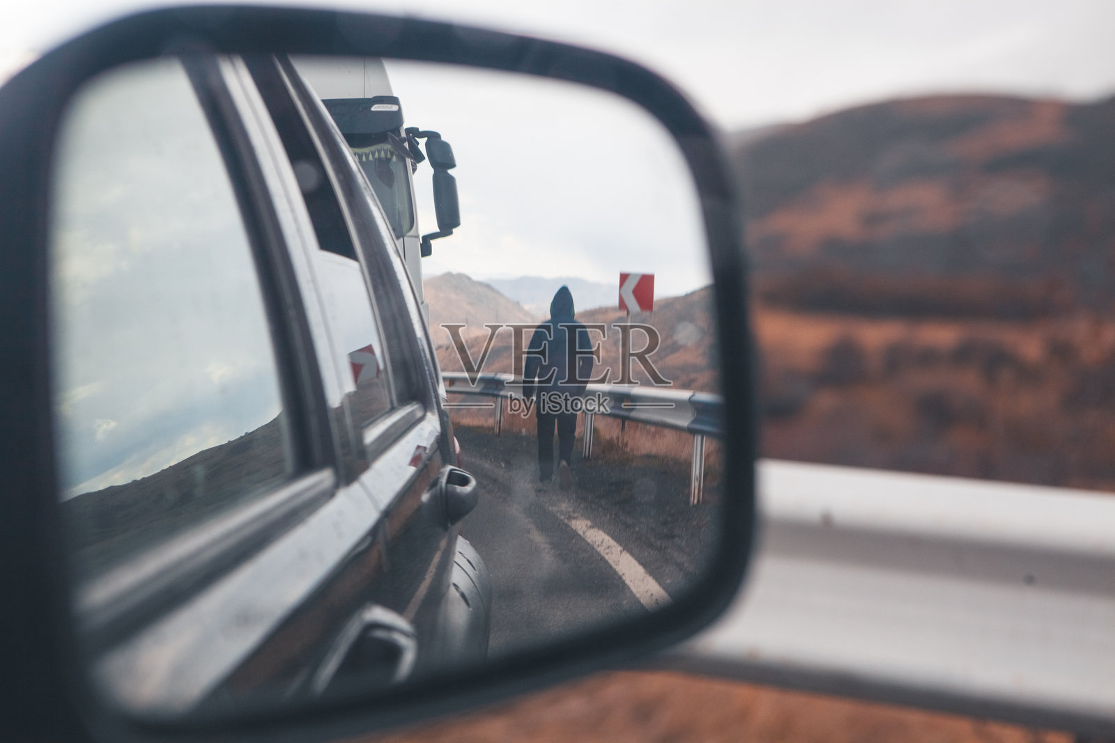 镜子中的视角：男人与路上的汽车照片摄影图片