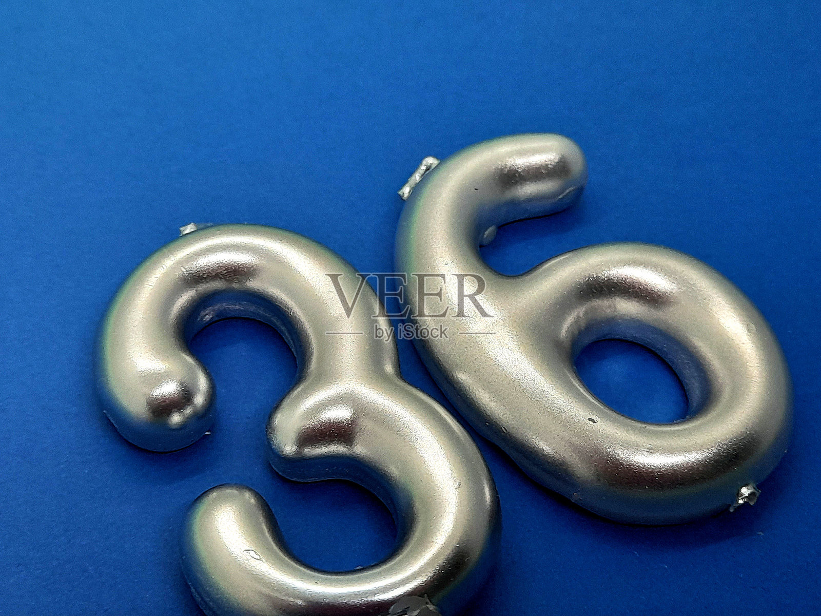 蓝色背景上的36号蜡烛照片摄影图片