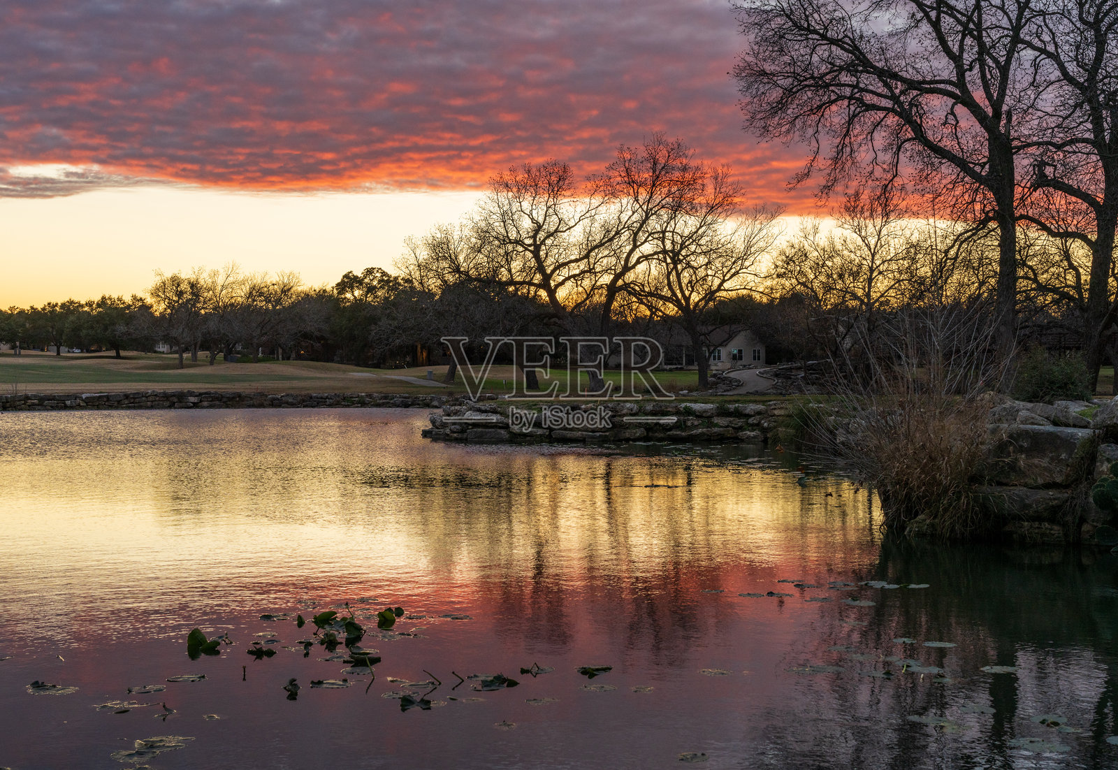 德克萨斯州乔治城附近的遗产山公园湖泊和高尔夫球场上演绎出戏剧性的日落景象照片摄影图片