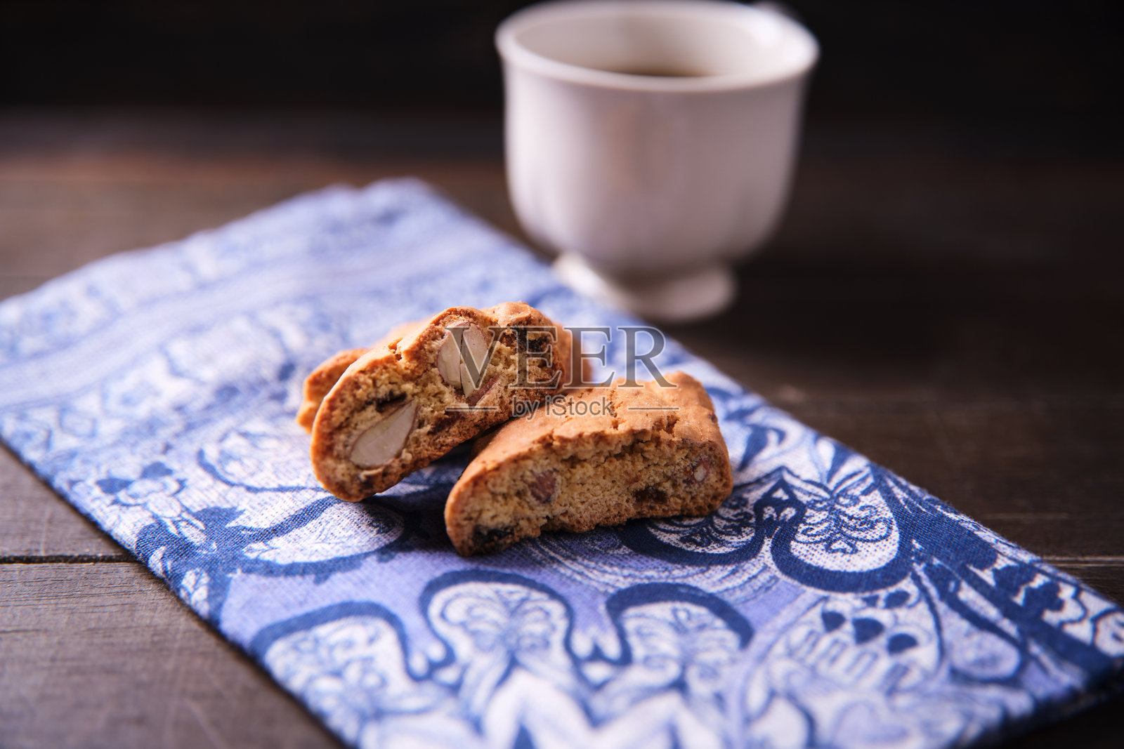 意大利饼干（Cantuccini）和一杯咖啡放在深色木质背景上。特写。照片摄影图片