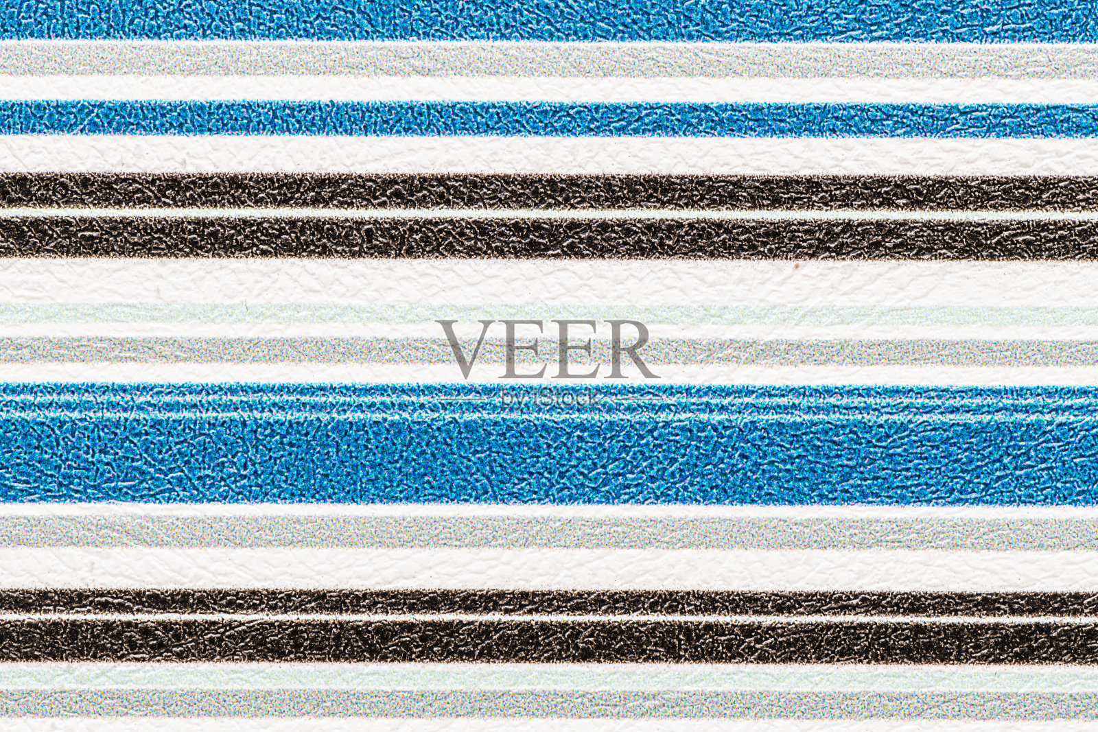 带有交替蓝色、黑色、白色和灰色的条纹纹理，形成一种视觉上吸引人的图案，表面有质感。照片摄影图片