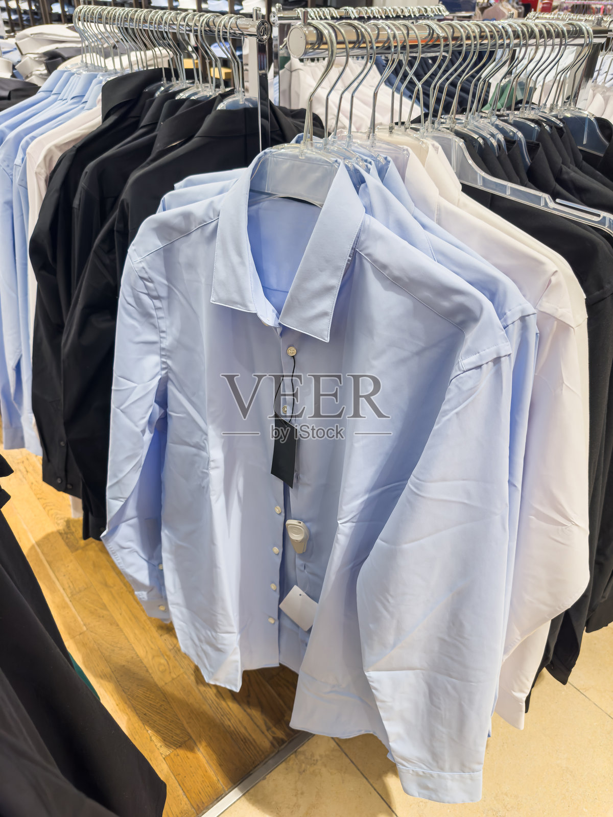 时尚店内新款男士衬衫挂在衣架上照片摄影图片