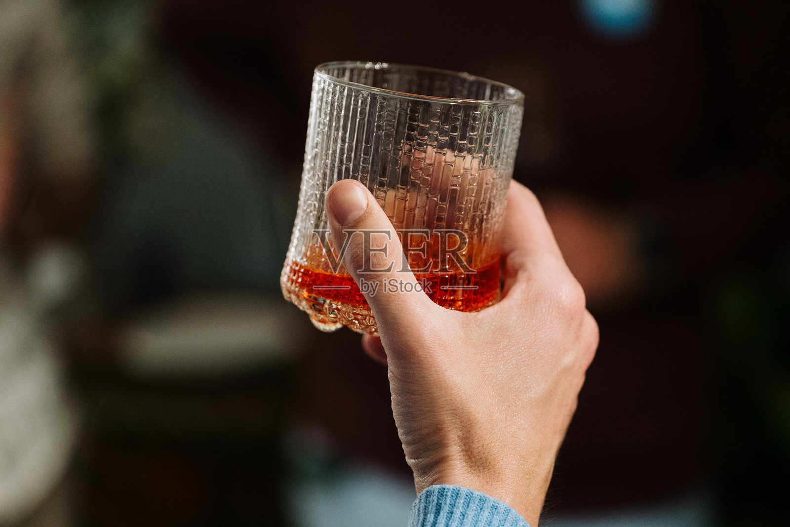 一个人自信地将一杯酒牢牢握在手中照片摄影图片