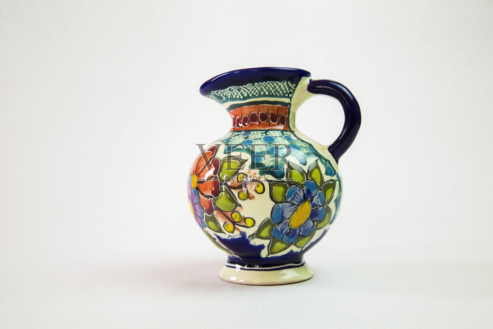 来自墨西哥普埃布拉的传统塔拉维拉陶器水壶，展示了生动的花卉图案照片摄影图片