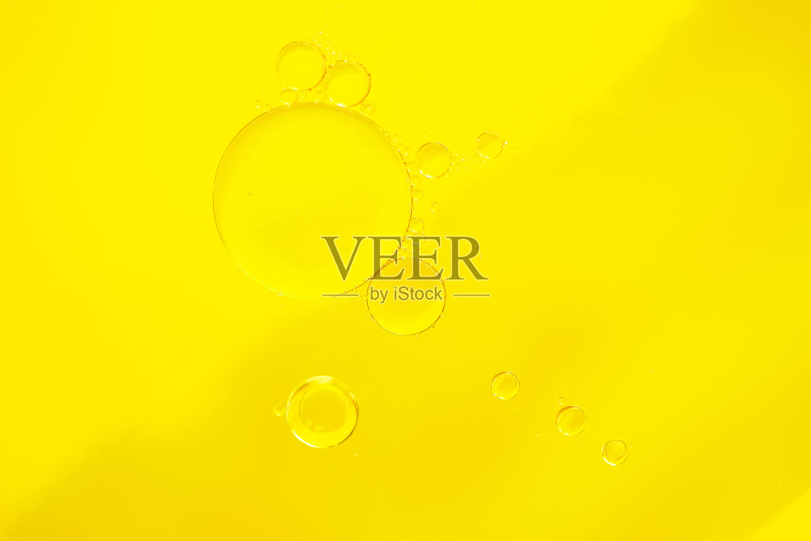 明亮黄色背景上的抽象油泡。微距摄影照片摄影图片