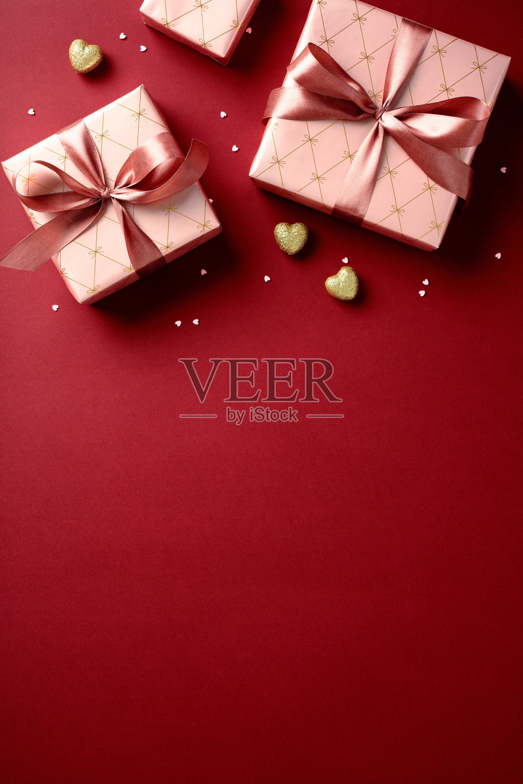 从上方看情人节礼品盒，里面装有心形糖果，背景为红色竖条纹。照片摄影图片