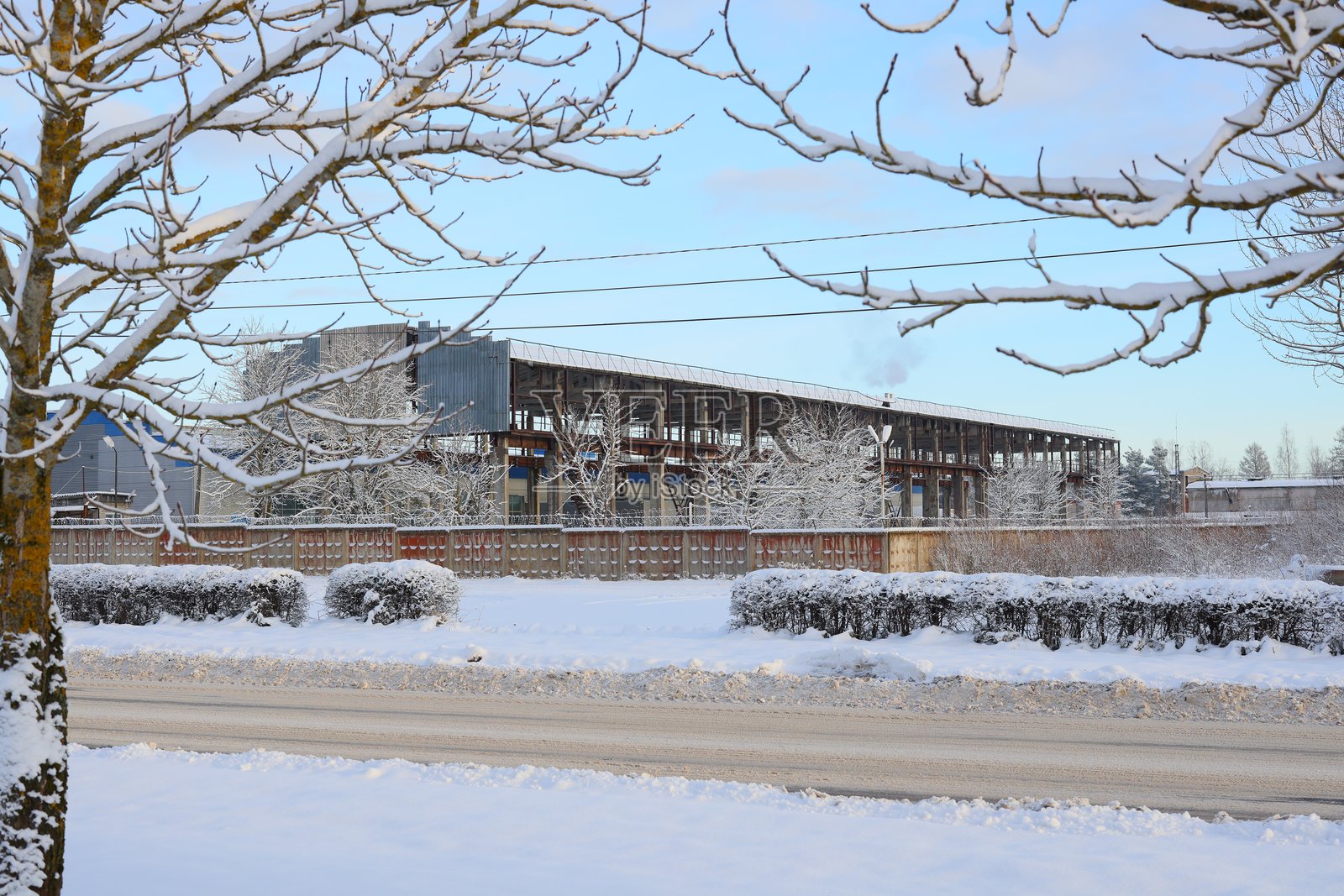 一幅如画的冬季场景，工业建筑坐落在一片雪白的覆盖之中照片摄影图片