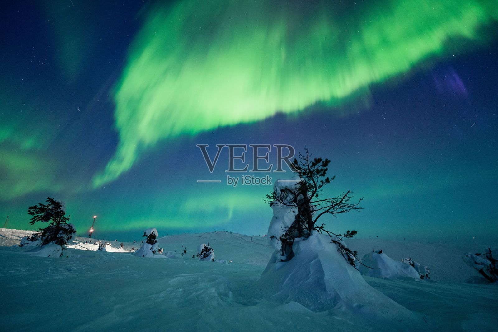 令人惊叹的北极光照亮了雪-covered的夜空照片摄影图片