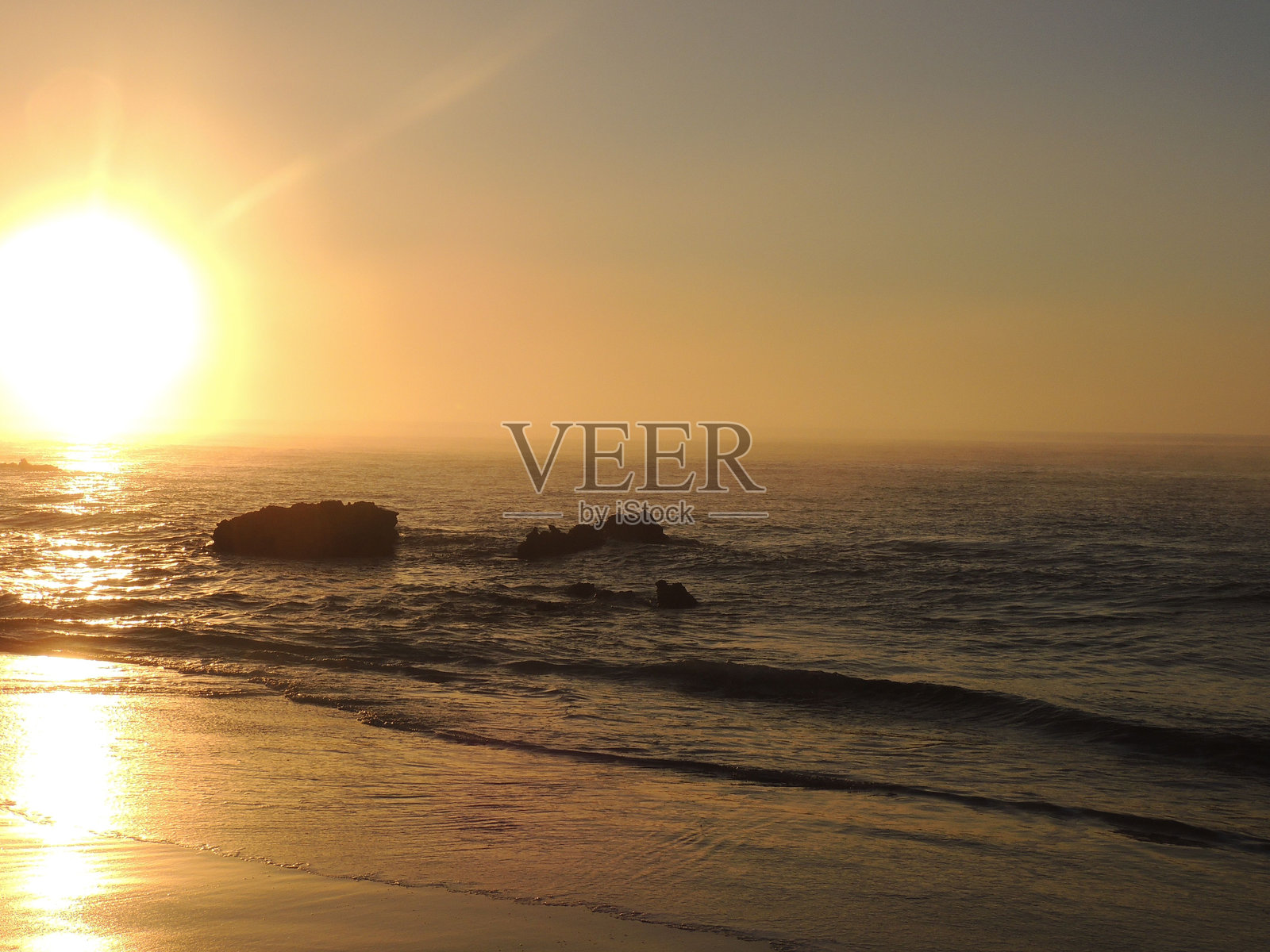 宁静的日落映照在平静的海洋上照片摄影图片