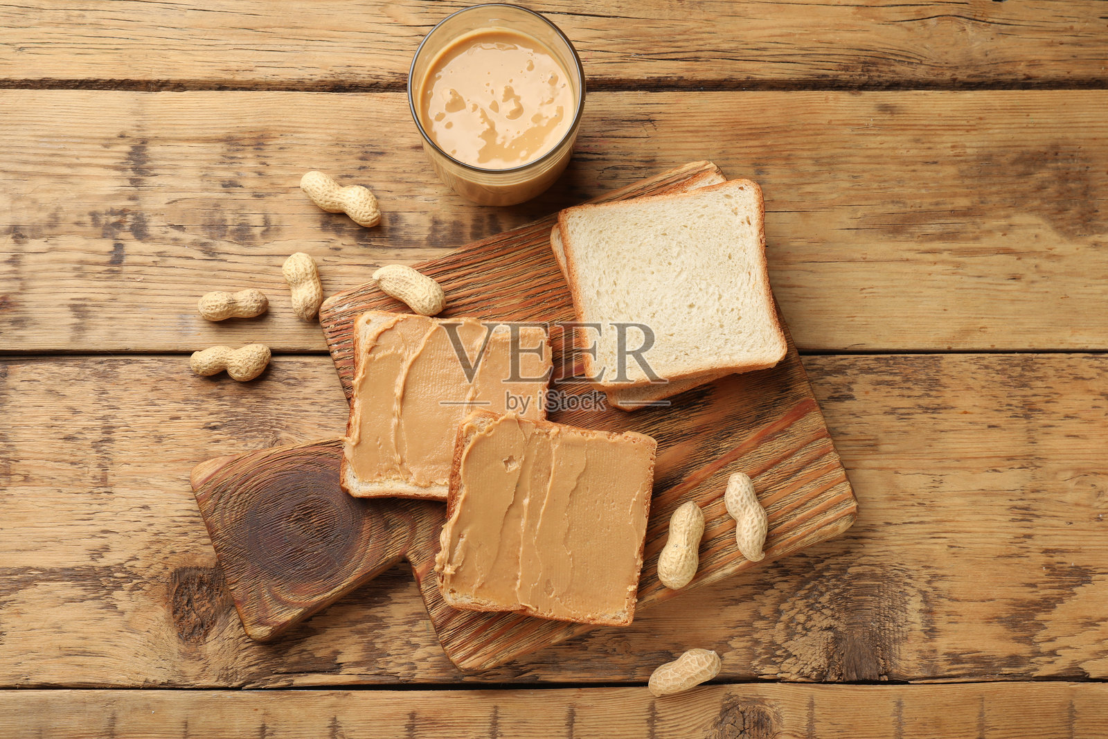 美味的花生酱三明治和花生在木桌上的俯视图照片摄影图片