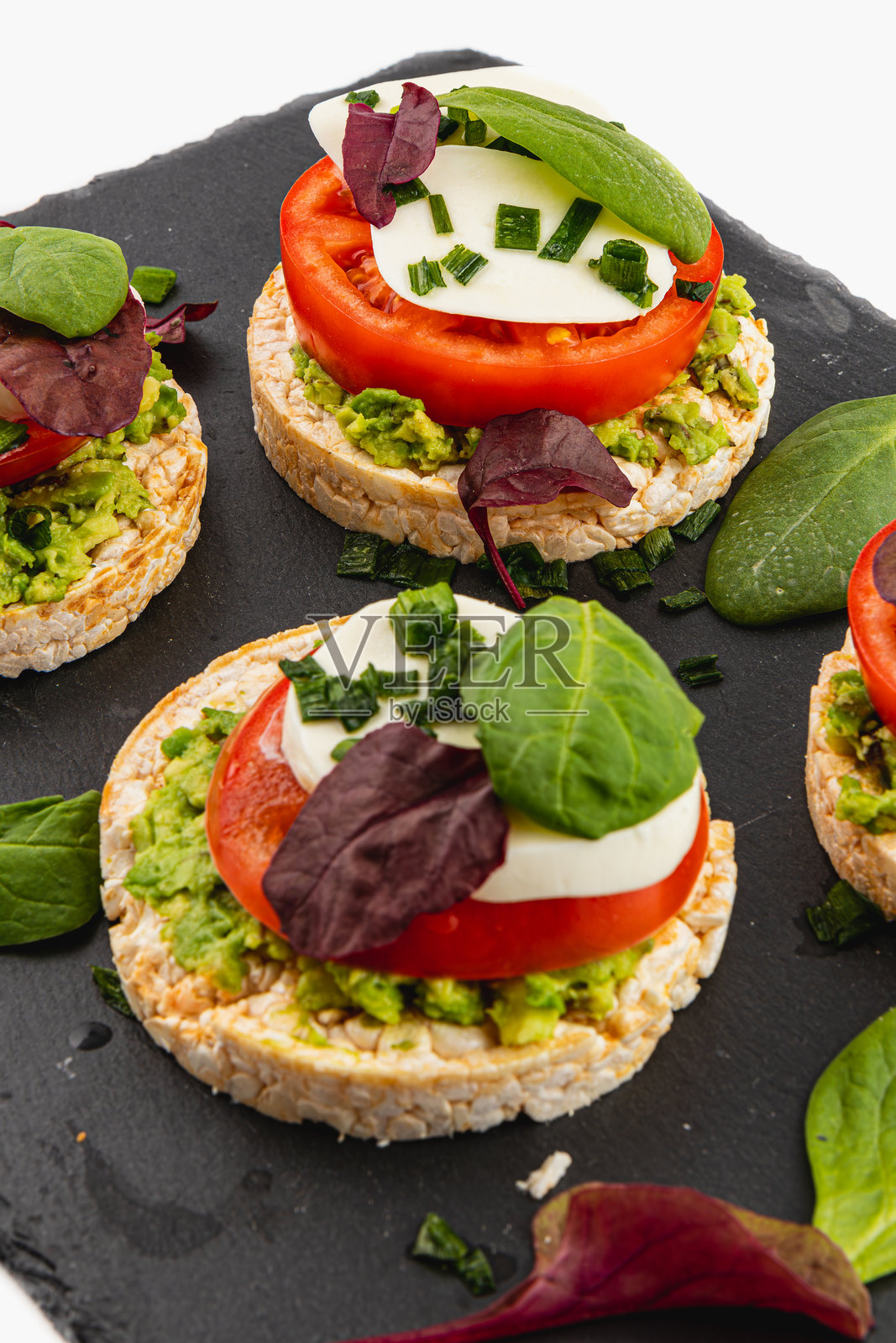 健康饮食概念，米饼配鳄梨、马苏里拉奶酪、菠菜和洋葱照片摄影图片