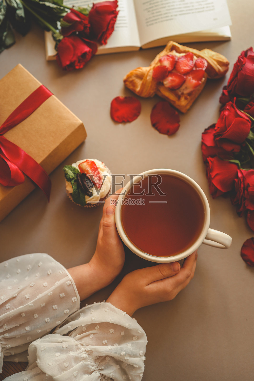 女孩手握茶杯，置身于节日氛围中照片摄影图片
