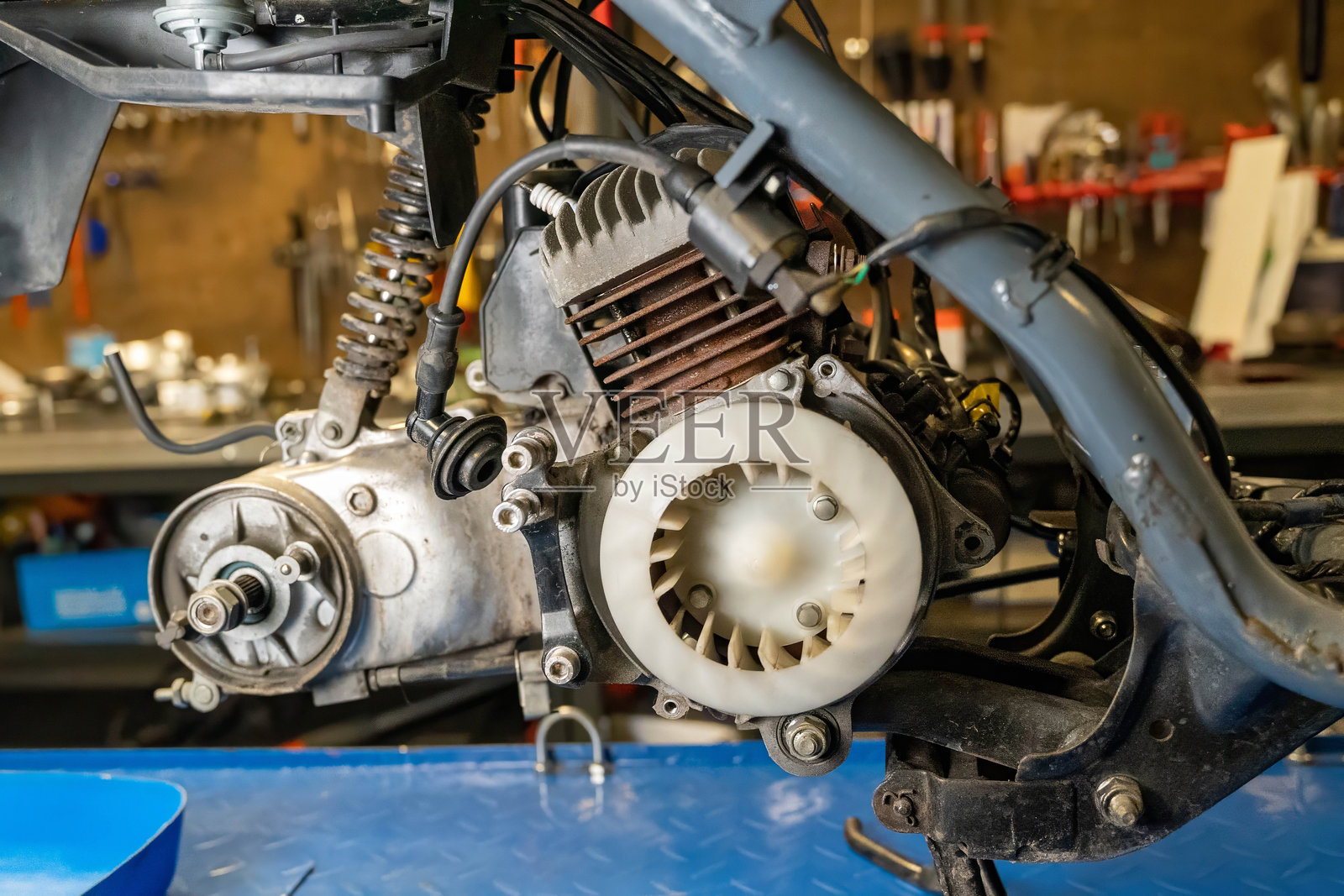 机械师在车间修理滑板车引擎照片摄影图片