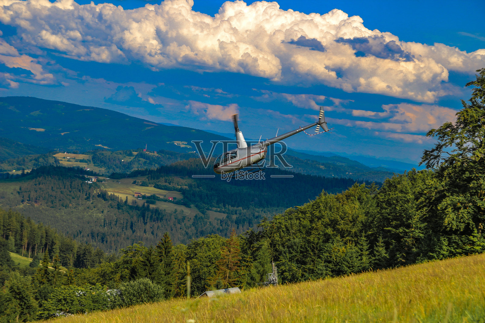 一架小型轻型直升机在山区进行救援行动时降落照片摄影图片