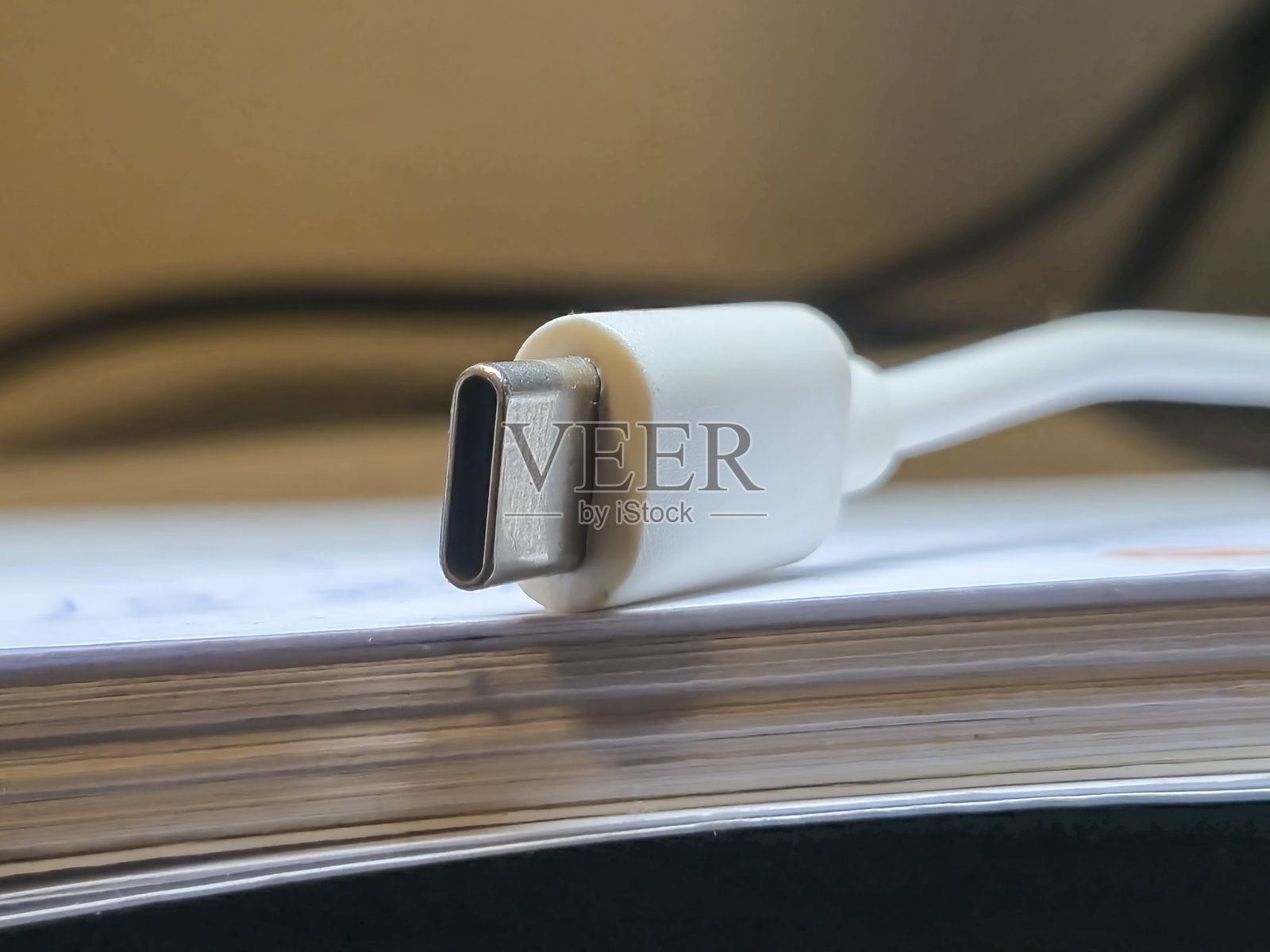 白色电缆上的USB-C连接器特写，展示现代科技的多功能性。照片摄影图片