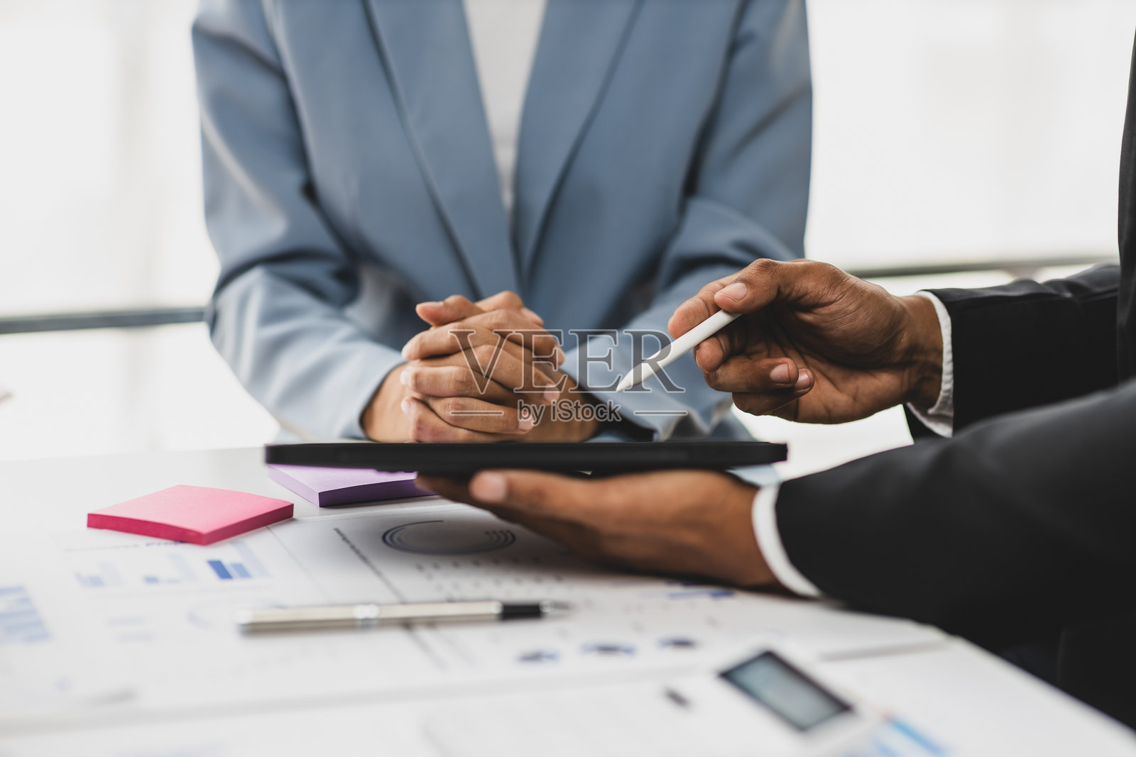 商务同事在数字平板上工作并分析财务数据。讨论会议中展示成功的商业财务报告分析。照片摄影图片