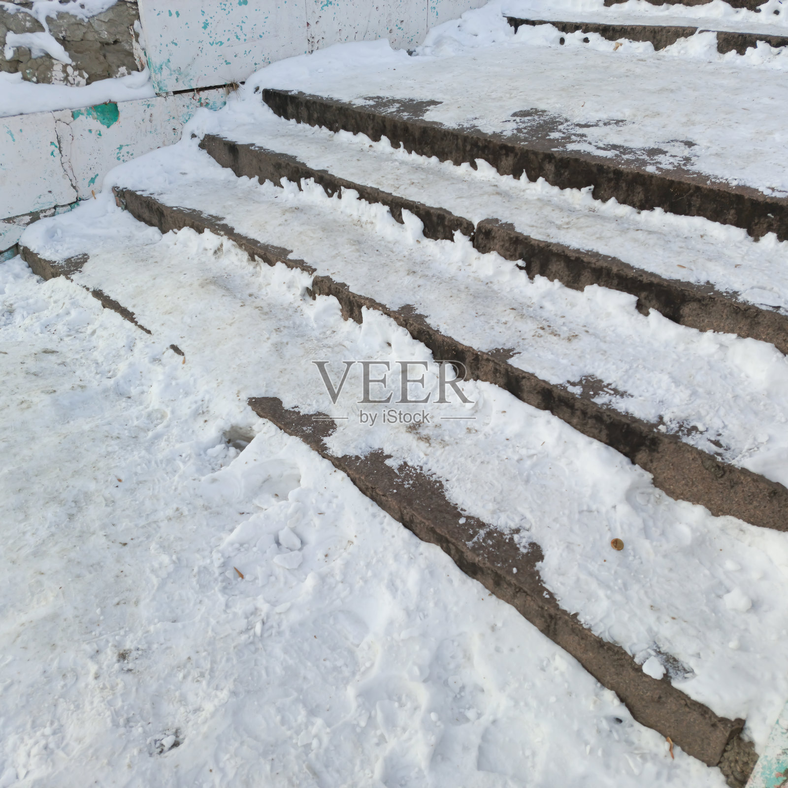 外面的楼梯上积雪。城市中的未铺砌道路。雪中的沥青。滑溜的楼梯。照片摄影图片