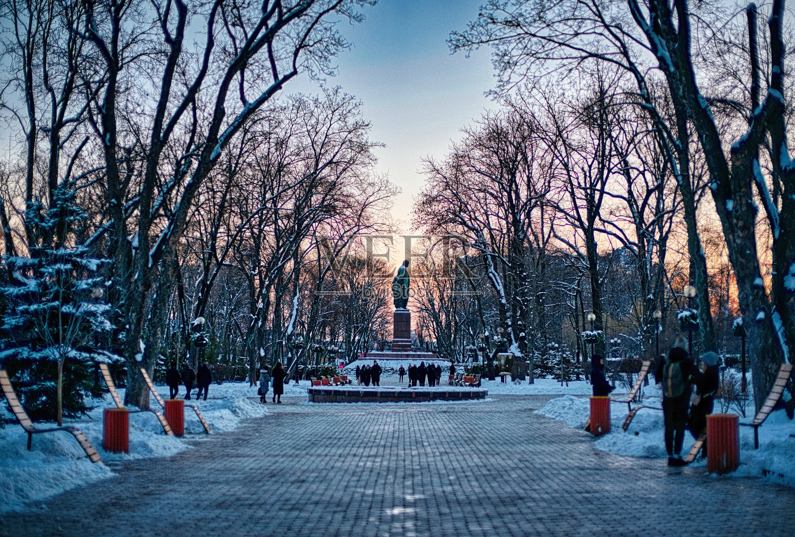 雪地公园中的雕像在日落时分照片摄影图片