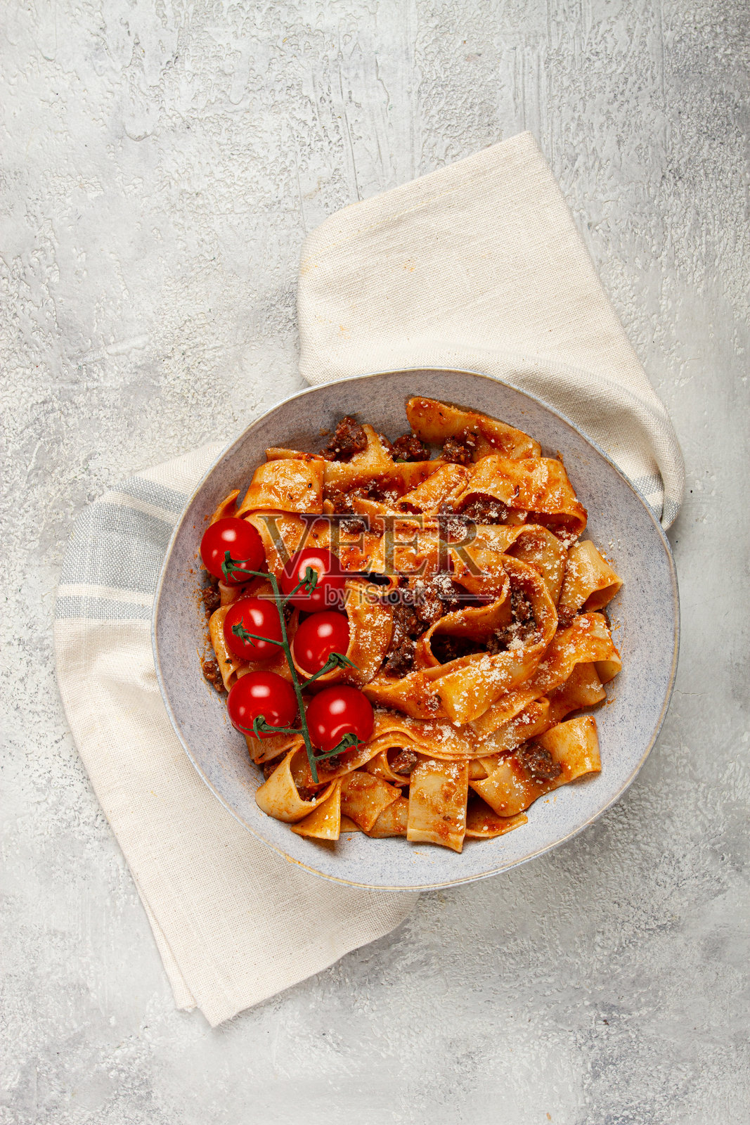 自制的宽面条配博洛尼亚酱，上面撒有帕尔马干酪和樱桃枝，周围没有人。照片摄影图片