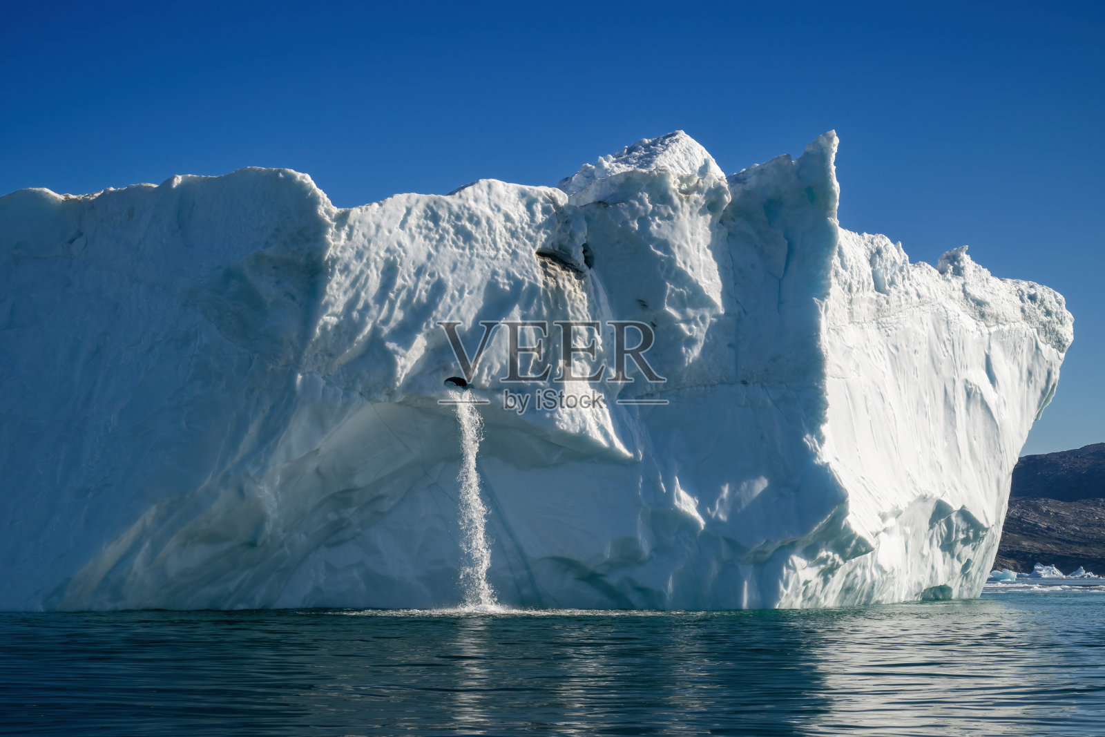 格林兰伊卢利萨特的迪斯科湾漂浮着巨大的冰山和瀑布照片摄影图片