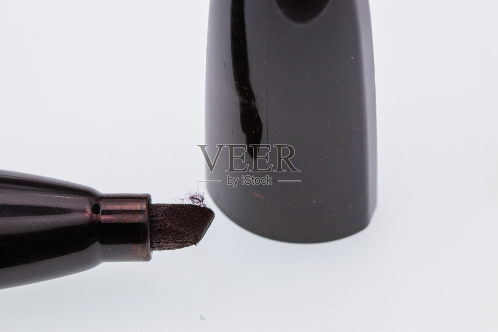 黑色粗头马克笔和盖子在白色背景上照片摄影图片