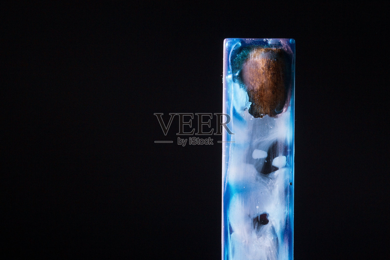 艺术树脂吊坠，展现自然木纹与空灵蓝色漩涡。照片摄影图片