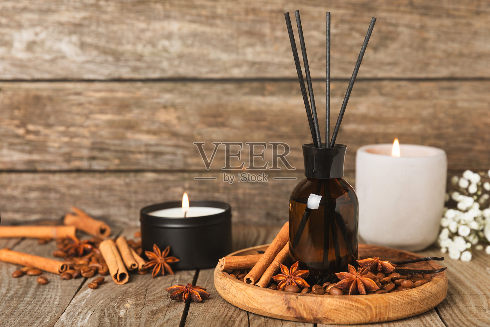 木桌上的芳香藤条空气清新剂。具有天然水果、花香和香料香气的扩散器。室内香氛。家用奢华香水。橙子、青柠、咖啡、肉桂、八角、香草和兰花。照片摄影图片