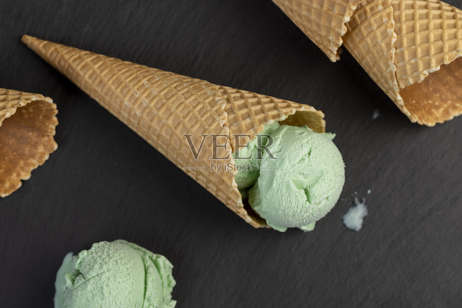 黑色石板表面上的薄荷味绿色冰淇淋照片摄影图片