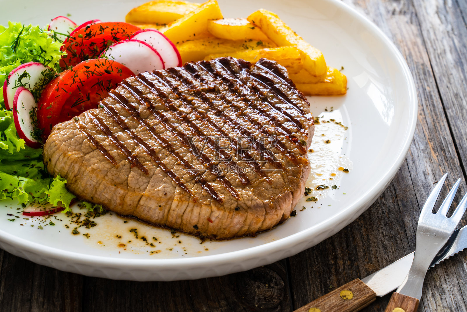 木桌上的烤牛肉西冷牛排配薯条照片摄影图片