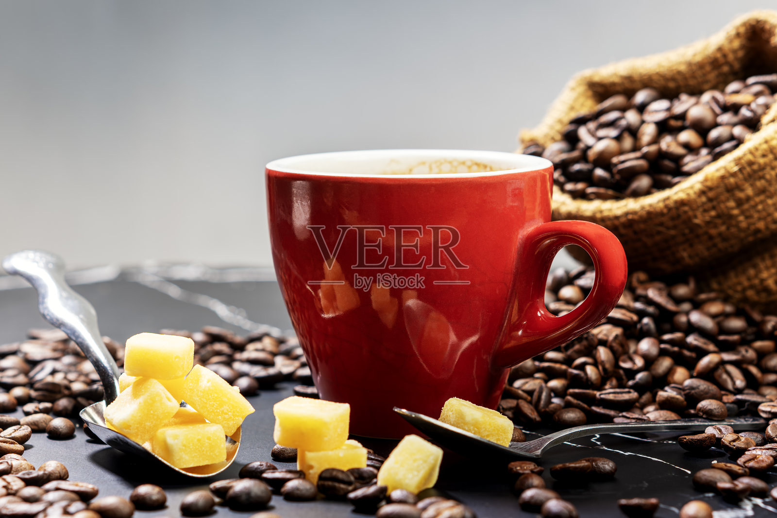 一杯黑色热咖啡，配有红糖块和咖啡豆，摆放在古老的木质纹理背景上。留白空间。照片摄影图片