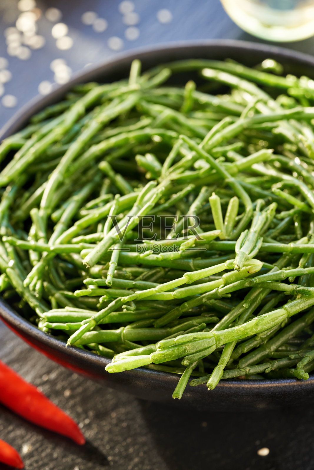 新鲜的绿海蓬或海苔在桌子上的碗里，配有芝麻和辣椒照片摄影图片