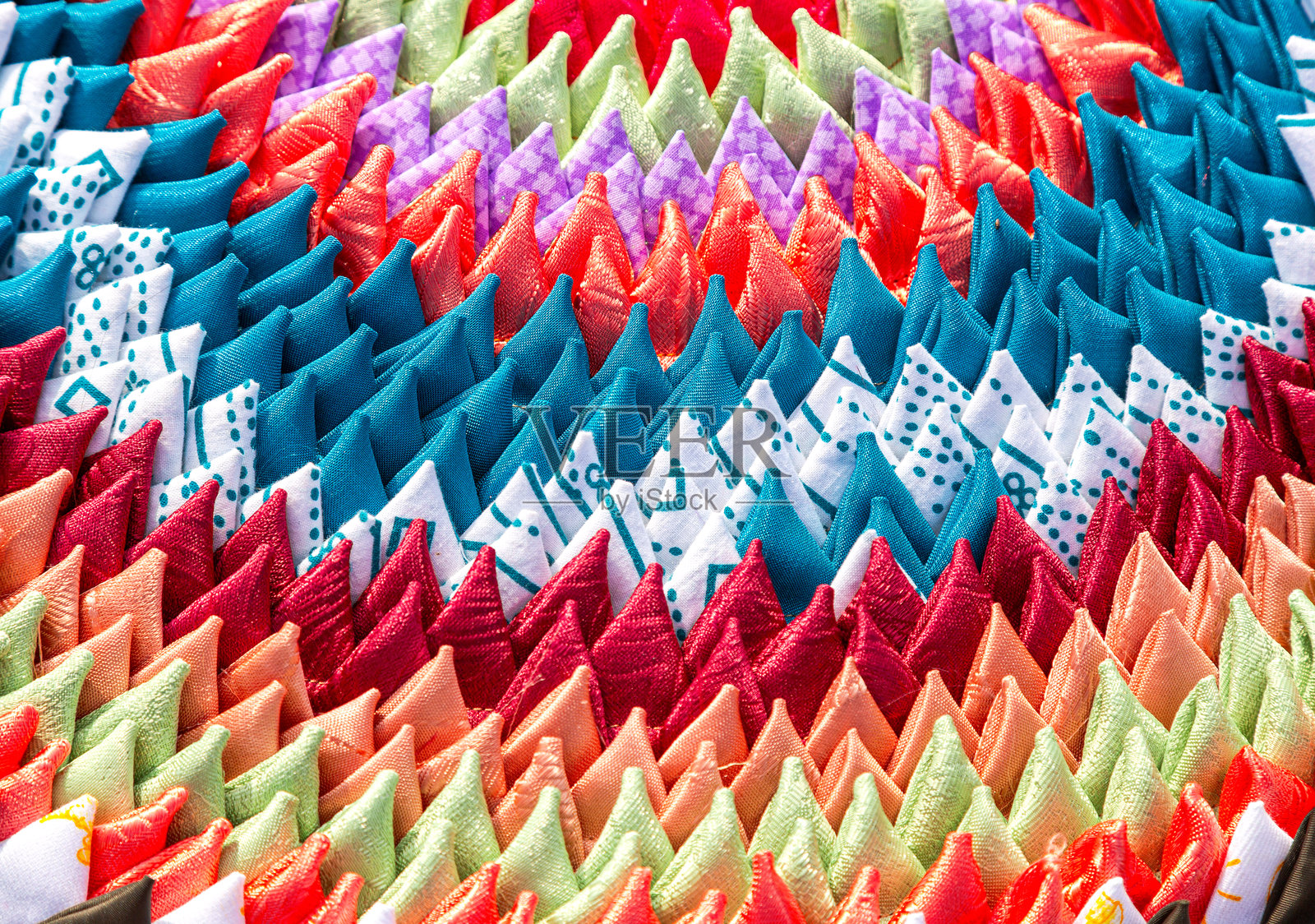 手工制作的多彩门垫创意背景。由不同颜色的织物构成的地毯纹理。照片摄影图片