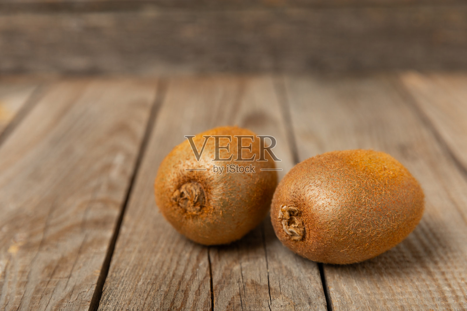 木质背景上的猕猴桃。整颗水果和切片的绿色猕猴桃放在桌子上。新鲜成熟多汁的猕猴桃。热带水果。有机水果。健康饮食。留白空间。照片摄影图片