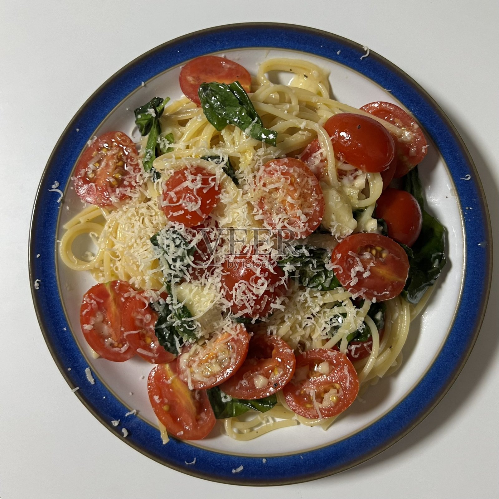 一盘完美煮熟的意大利面，上面浇有浓郁的番茄酱和新鲜的香草。非常适合食品摄影和菜单，生动展现了意大利美食的精髓。照片摄影图片