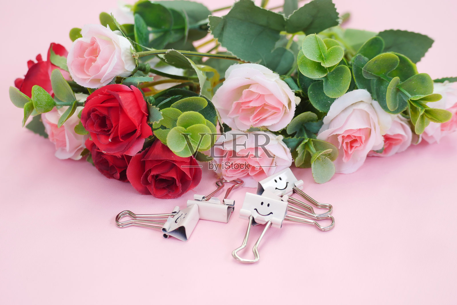 粉色底座上的玫瑰花束，留有空白处可供文字使用，适合情人节。照片摄影图片