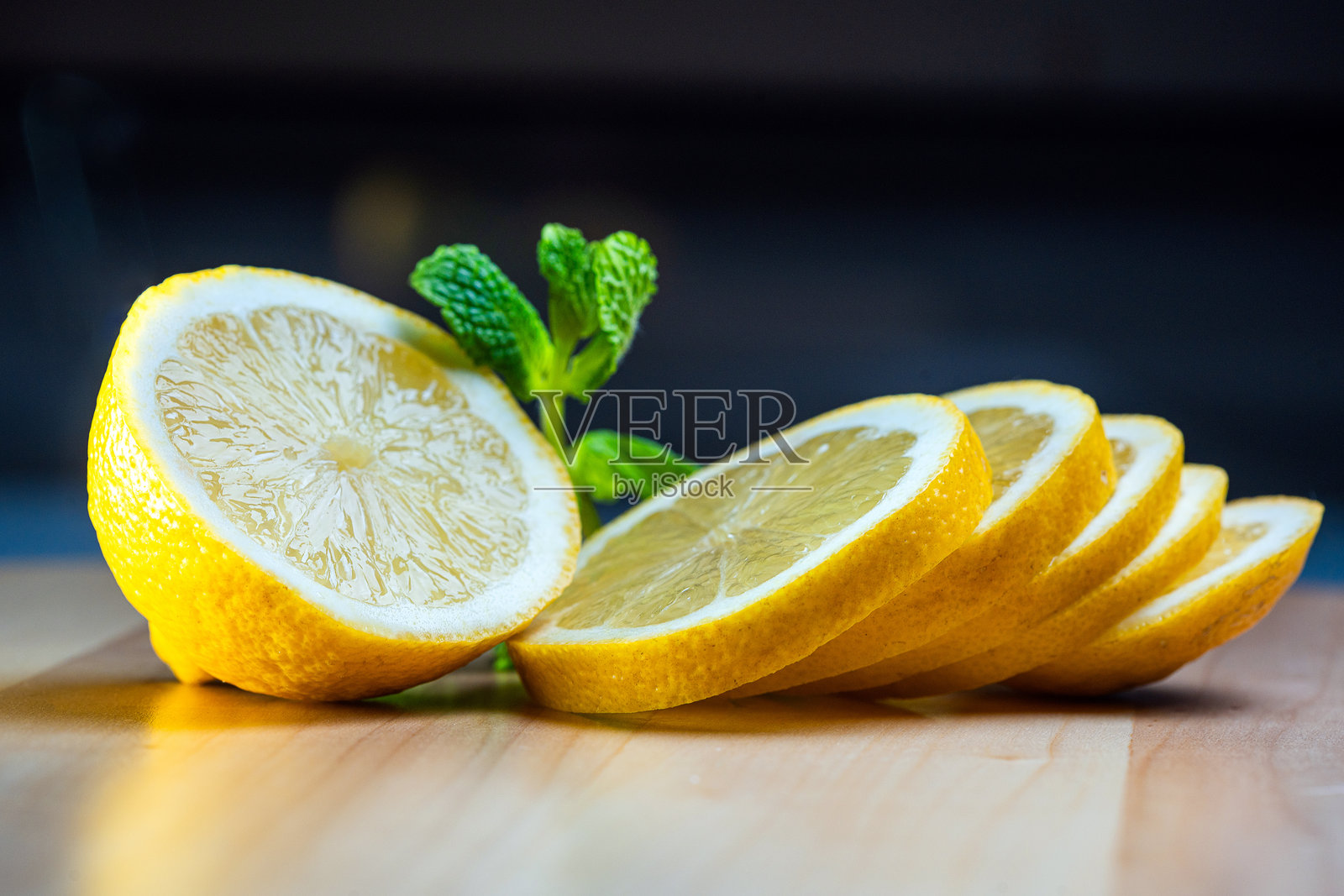 新鲜切片的柠檬与绿色薄荷在木质背景上照片摄影图片
