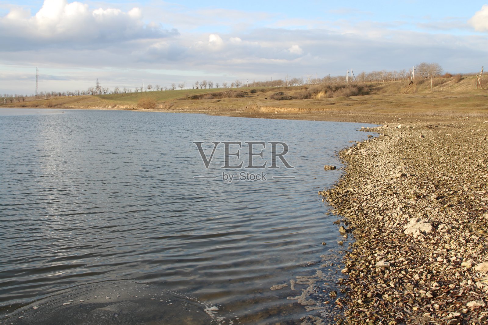 一片水域，旁边有岩石和草地照片摄影图片