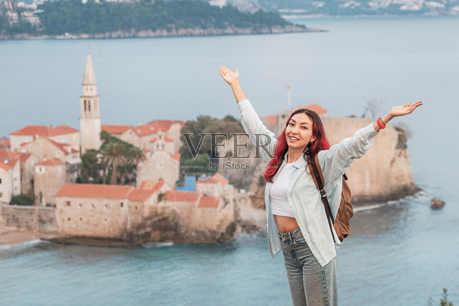 一位无忧无虑的女背包客在黑山的布德瓦欧洲海滨城市享受夏季旅行，探索著名地标，捕捉旅行的自由与美丽。照片摄影图片