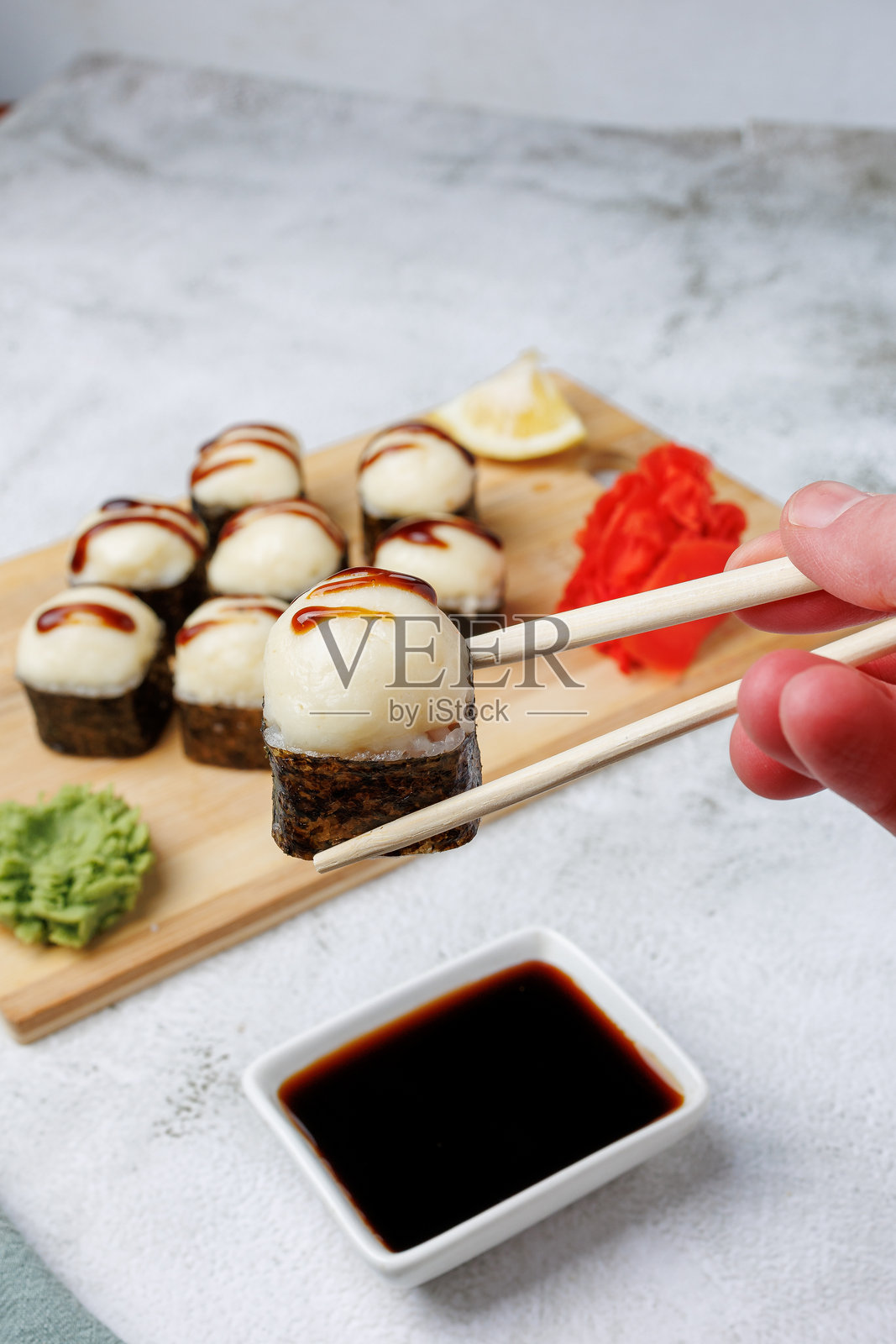 烤奶酪寿司卷，鳗鱼酱特写，撒上芝麻、柠檬、酱油、生姜、芥末，寿司摆放在浅色背景上，静物，食物，日本料理照片摄影图片