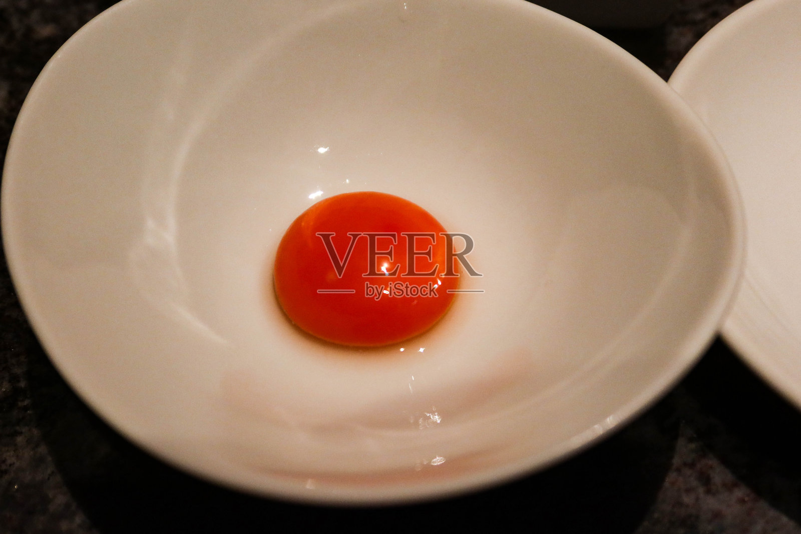 白碗中生橙色日本蛋黄的特写，留有空白空间照片摄影图片