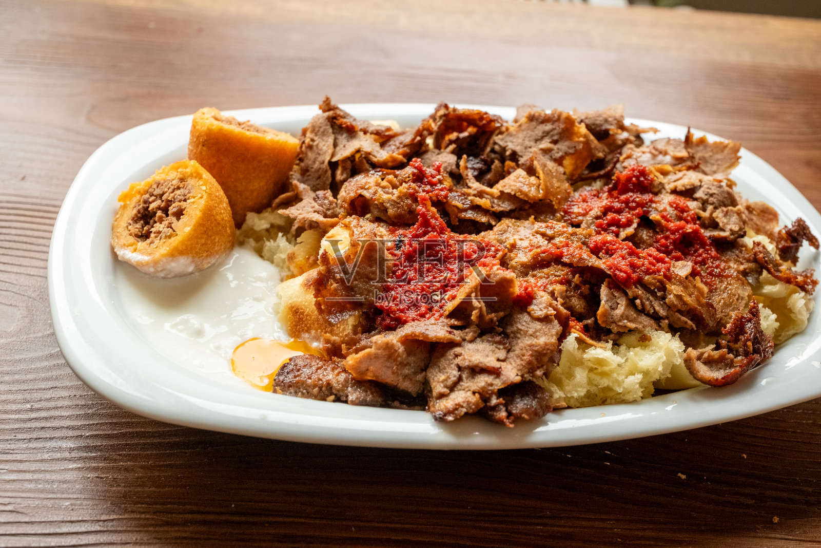 土耳其地方菜肴伊斯肯德尔烤肉卷盛在椭圆形盘子里照片摄影图片