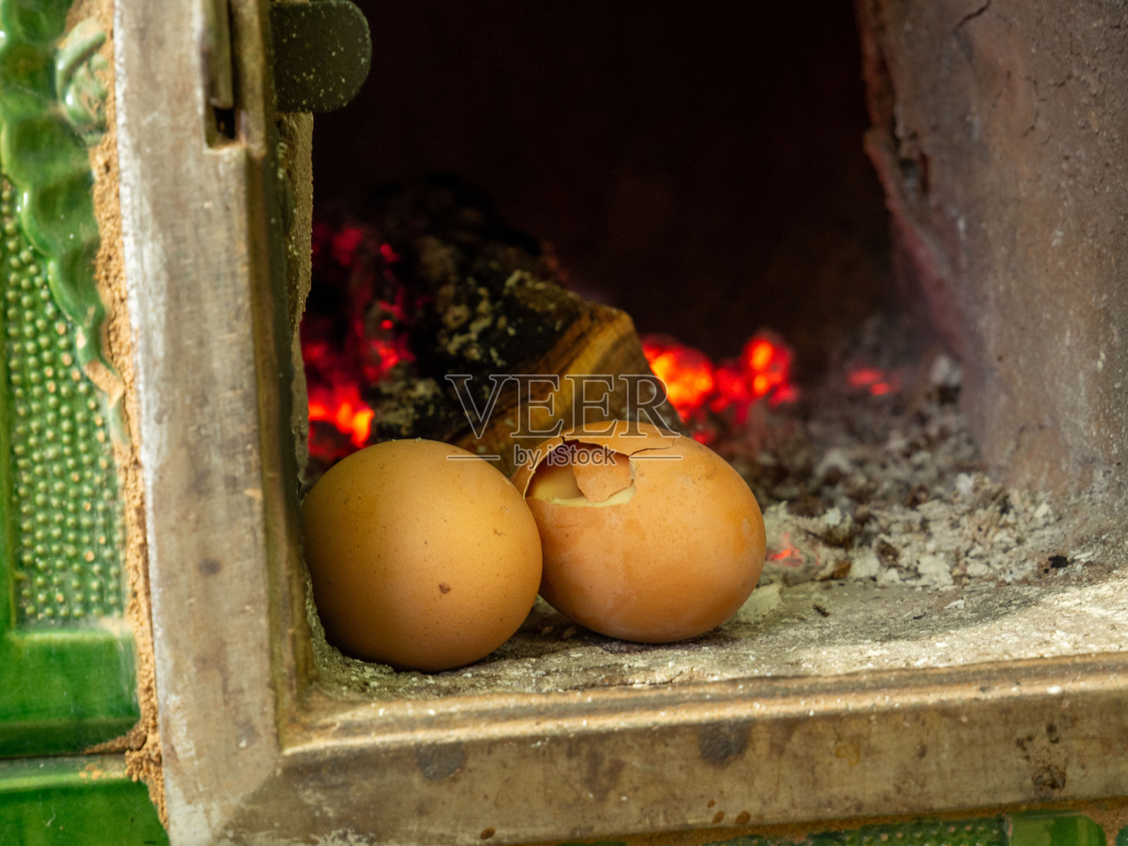 前景中有火焰和木框的裂纹和完整鸡蛋特写镜头照片摄影图片