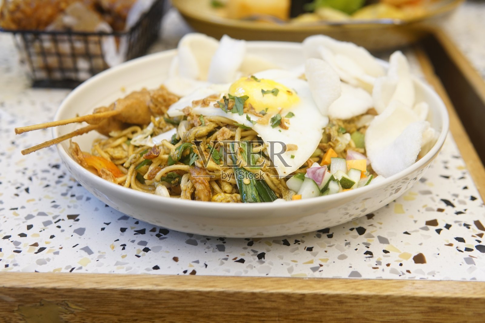 一碗盛满食物的菜肴，上面放着一个煮得恰到好处的鸡蛋，展现出美味可口的餐点。照片摄影图片