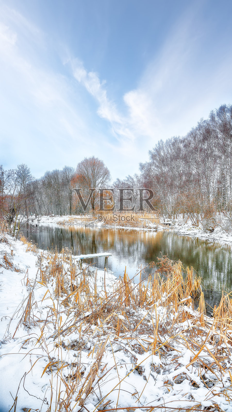 城市公园中美丽的风景，雪-covered树木和美丽的冰冻河流。照片摄影图片