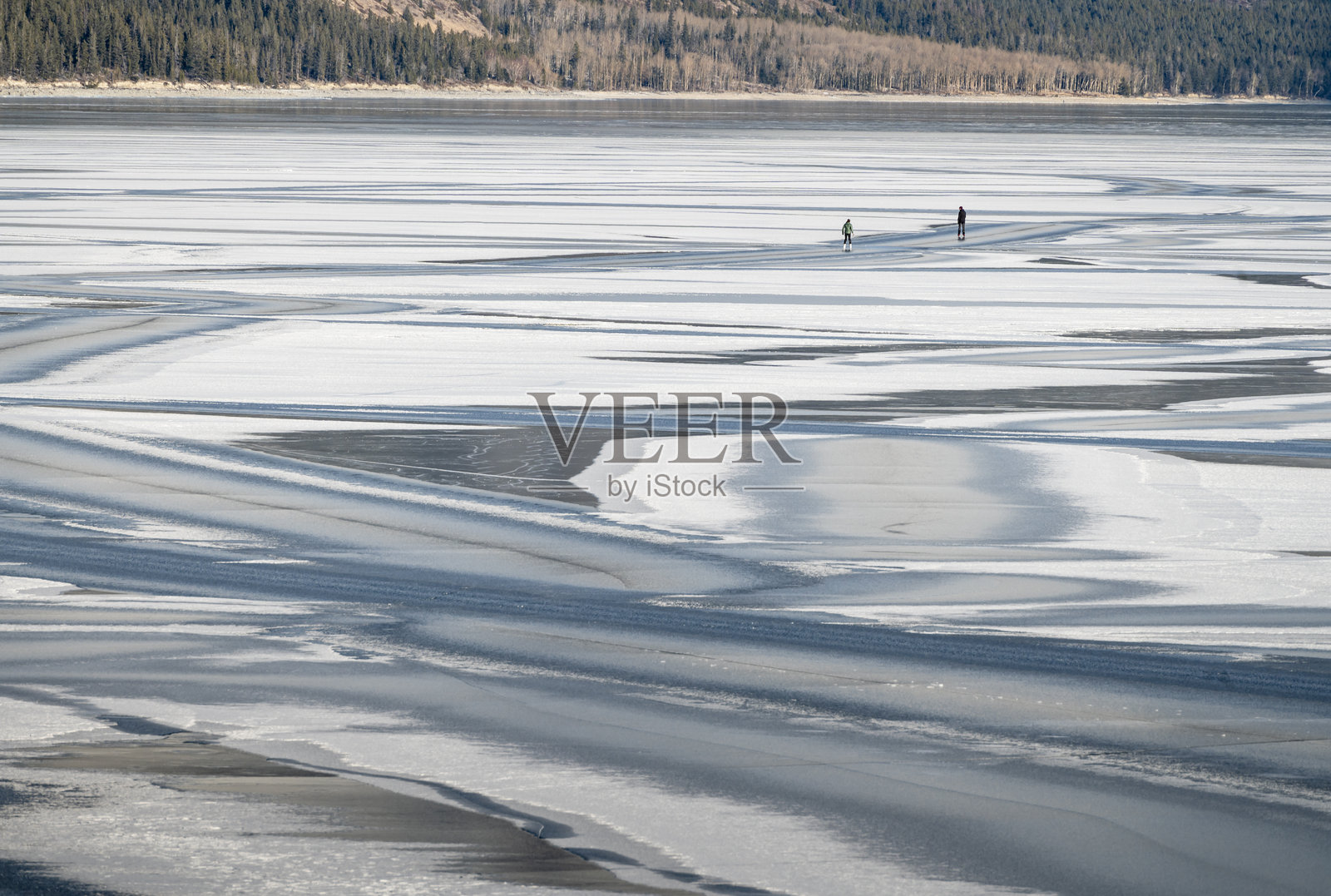 冰湖上的雪花图案和滑冰者照片摄影图片