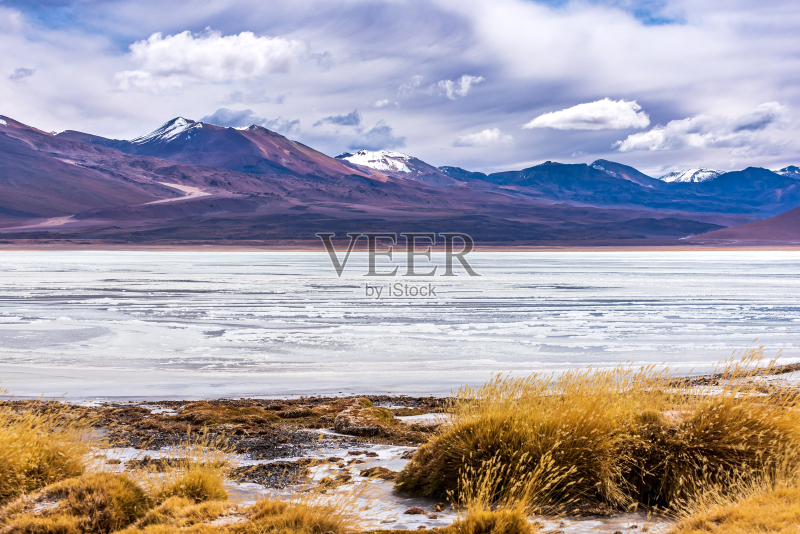 玻利维亚高原上山脉峰顶的积雪和冰冻湖泊照片摄影图片