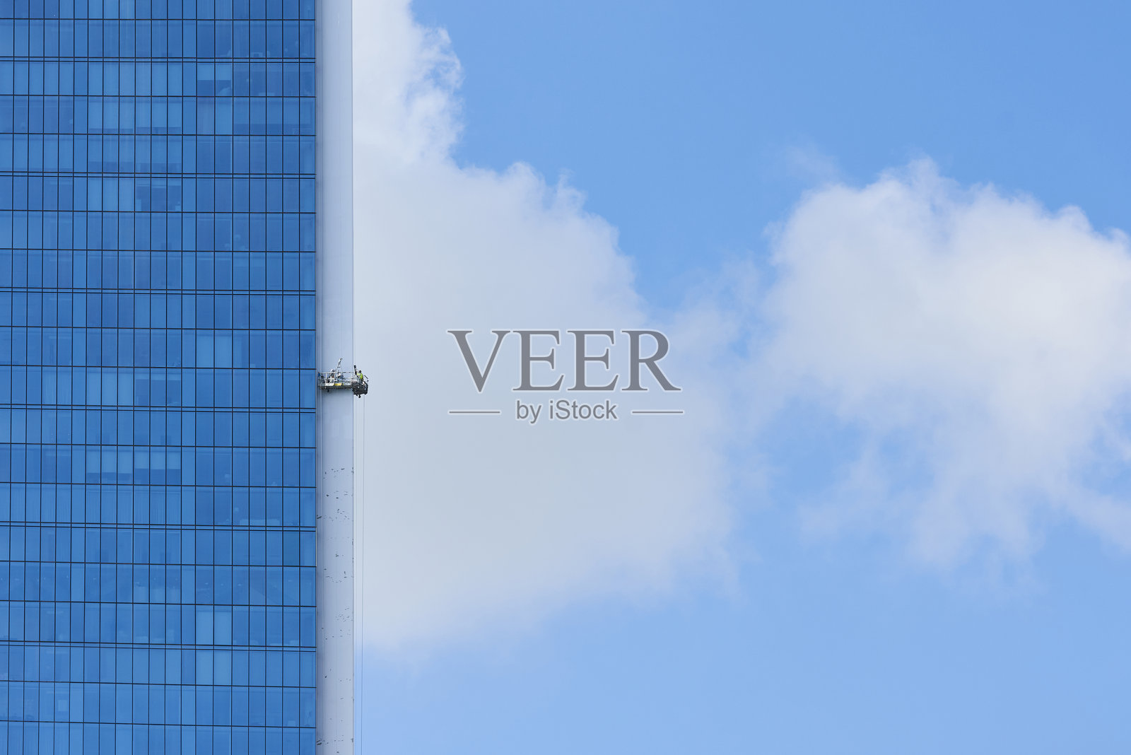 工人在脚手架上为摩天大楼涂漆的画面照片摄影图片