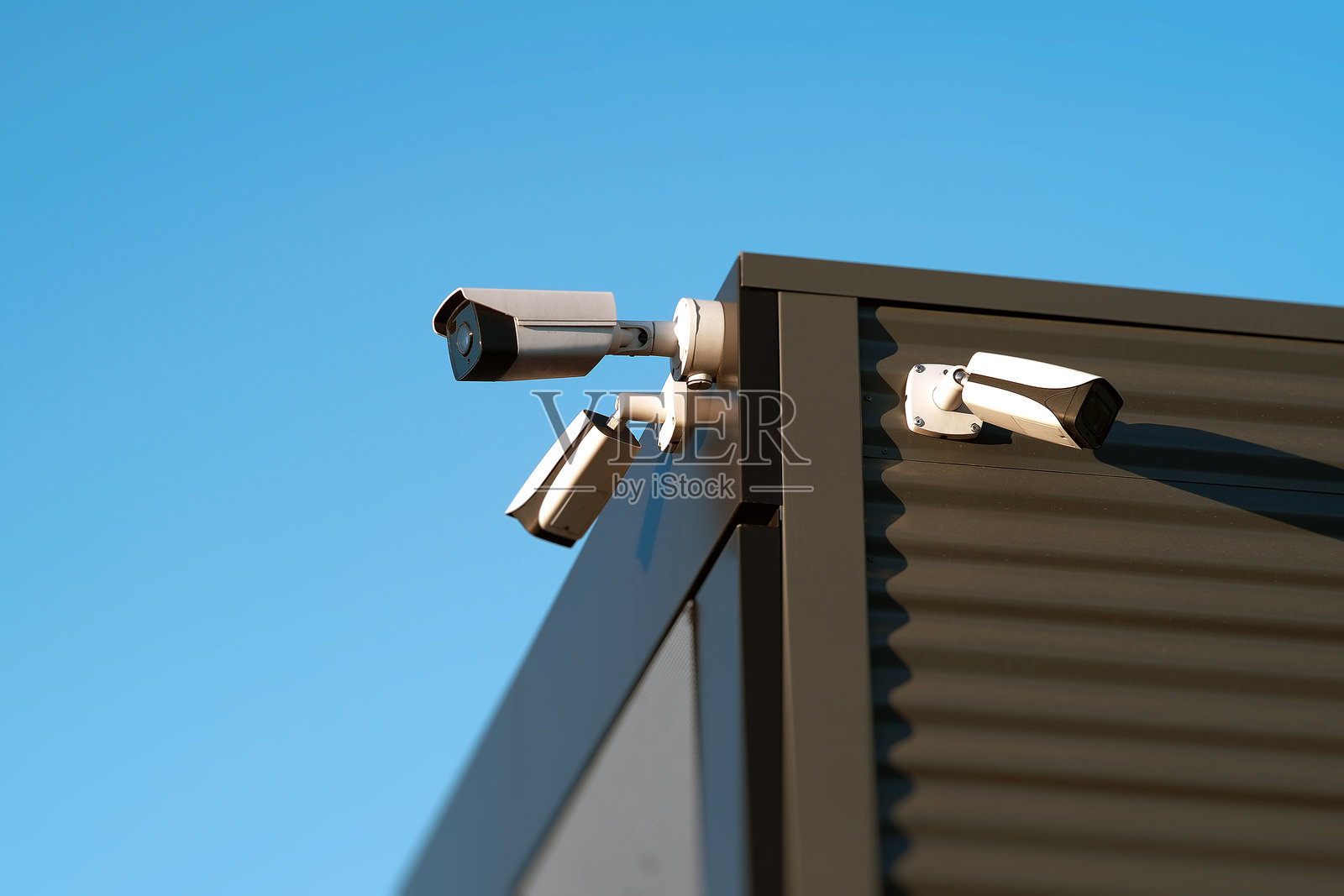 这张图片展示了现代建筑外部安装的多个监控摄像头的特写视图。照片摄影图片