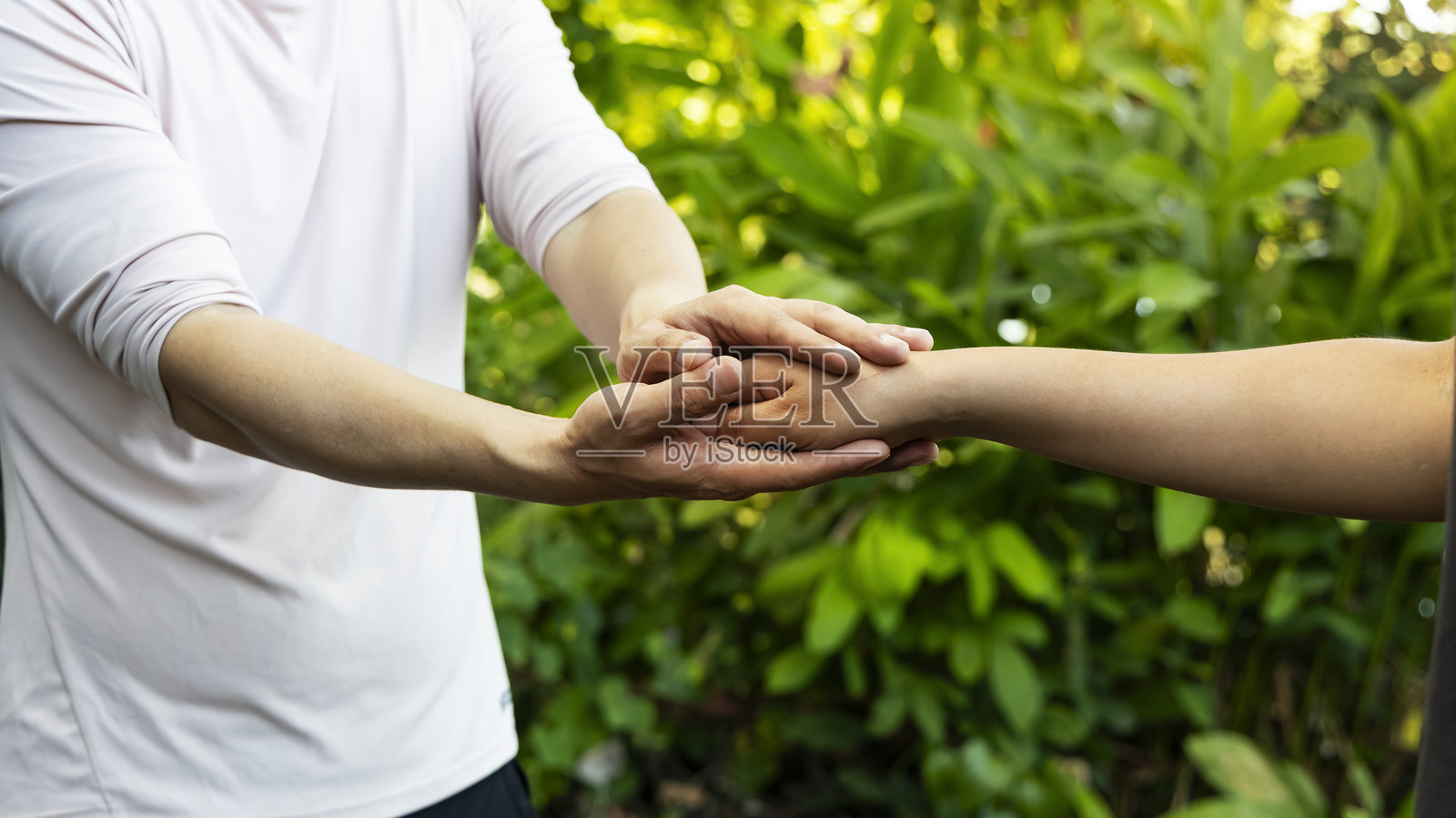 男人的手伸出援助之手，象征着信任与同情，公园中的镜头光晕场景照片摄影图片