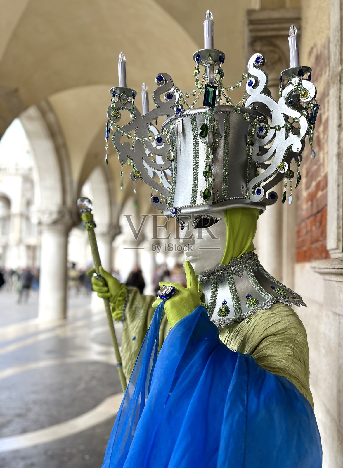 在威尼斯狂欢节上，神秘的戴面具者佩戴着华丽的吊灯头饰照片摄影图片